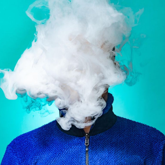 a man blowing out vape clouds 